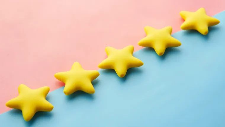 Étoiles jaunes symbolisant une note d'avis clients sur fond bleu et rose