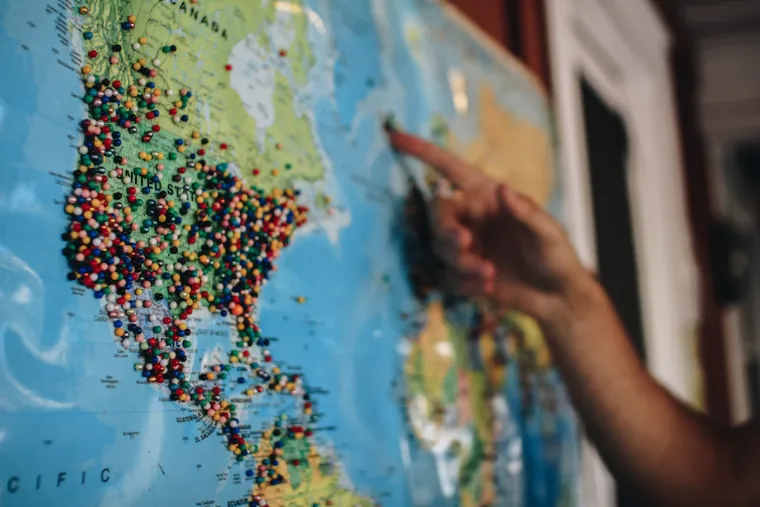 Personne pointant des épingles sur une carte pour plusieurs établissements PME